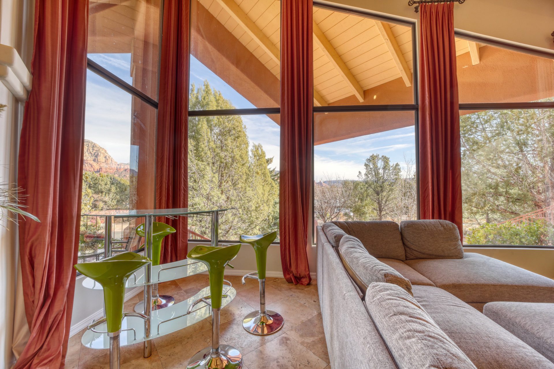 Vaulted living room with floor-to-ceiling windows and red rock views